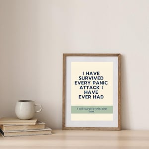 May include: A rectangular wooden frame containing a cream-colored print with dark blue text that reads: I HAVE SURVIVED EVERY PANIC ATTACK I HAVE EVER HAD. Below this, a sage green horizontal bar features the text: I will survive this one too.
