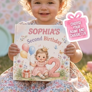 May include: A hardcover children's book titled SOPHIA'S Second Birthday featuring a pastel illustration of a toddler wearing a crown, holding three balloons, and sitting next to a large number two and a gift box, with a pink gift tag graphic.