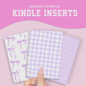 Könnte beinhalten: Drei Kindle-Einsätze mit verschiedenen Designs. Einer hat ein Muster aus lila Schleifen auf weißem Hintergrund. Ein anderer hat ein lila Vichy-Muster, und der dritte hat ein lila Gittermuster. Der Text "original cardstock" und "KINDLE INSERTS" steht oben.