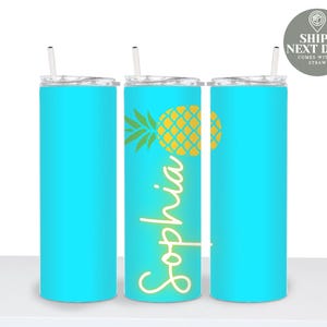 May include: Three turquoise insulated tumblers with straws. One tumbler features a yellow pineapple design and the name "Sophia" in white script. The tumblers are designed to keep drinks cold and are perfect for travel.
