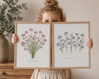 Puede incluir: Dos impresiones artísticas florales enmarcadas. Una impresión presenta un ramo de flores moradas atadas con un lazo, la otra tiene flores azules. Ambas están en marcos de madera clara. El texto es visible en la parte inferior.