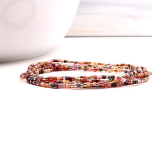 Bracelet multi-tours de perles enfilé sur un cordon élastique résistant. Coupe glacée aux framboises. Peut être porté en bracelet, en chaîne de cheville ou en collier.