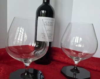 Wine glass with attached coaster.
