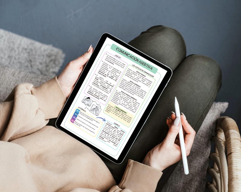 May include: A digital tablet displaying an educational infographic titled COMUNICACI&Oacute;N ASERTIVA. The screen features text in Spanish organized into sections about communication styles, including passive, aggressive, and assertive, with a white stylus.