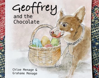Może przedstawiać: Kwadratowa okładka książki zatytułowana Geoffrey and the Chocolate autorstwa Chloe Menage i Grahame Menage. Ilustracja przedstawia brązowego psa w obroży, który oblizuje się, stojąc obok wiklinowego koszyka wypełnionego kolorowymi pisankami.