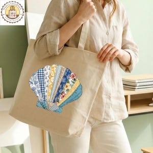 May include: A beige canvas tote bag featuring a seashell design. The seashell is composed of various patterned fabric strips in blue, yellow, and floral prints. The bag has a simple design with a rectangular shape and long handles.