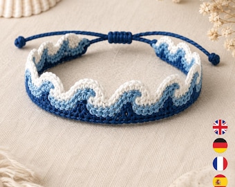 Könnte beinhalten: Ein gewebtes Armband mit einem sich wiederholenden Wellenmuster in Dunkelblau, Hellblau und Weiß. Das Design ist mit einem gewellten oberen Rand gefertigt und verfügt über einen verstellbaren Schiebeknotenverschluss aus passender dunkelblauer Kordel.