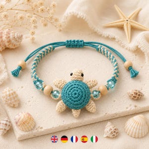 May include: A bracelet featuring a central crocheted turtle with a teal shell and beige limbs. The band is made of braided teal and beige cord, accented with light blue faceted beads and smooth wooden beads, finished with adjustable sliding knots.