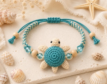 Könnte beinhalten: Ein Armband mit einer gehäkelten Schildkröte in der Mitte, die einen türkisfarbenen Panzer und beige Gliedmaßen hat. Das Band besteht aus geflochtener türkiser und beiger Kordel, verziert mit hellblauen Facettenperlen und Holzperlen sowie Schiebeknoten.
