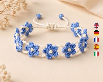 May include: A handmade bracelet featuring a series of blue crocheted flower motifs connected by a white cord. The bracelet includes an adjustable sliding knot closure with two small blue beads at the ends of the white string ties.