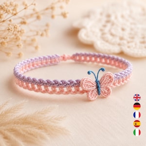 Può includere: Un braccialetto all'uncinetto fatto a mano caratterizzato da un design bicolore con una fascia superiore viola chiaro e una fascia inferiore rosa tenue. Una piccola farfalla all'uncinetto rosa tenue con corpo e antenne in filo blu scuro.