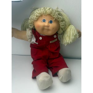 Muñeca Cabbage Patch Kids vintage de 1982, ojos azules, cabello rubio de lana, overol rojo.