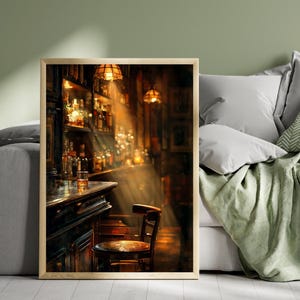 Puede incluir: Una impresión enmarcada de un interior de bar con poca luz. La imagen presenta una barra de madera con un vaso de líquido ámbar, una silla de madera y estantes llenos de botellas. La luz cálida atraviesa el espacio, creando un ambiente acogedor.
