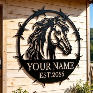 Puede incluir: Silueta negra de cabeza de caballo con melena fluida, rodeada por un diseño de alambre de púas. El letrero incluye el texto "YOUR NAME" y "EST. 2025". El letrero está montado en una pared de madera, con plantas en macetas delante.
