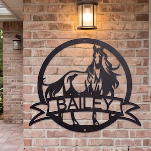 Könnte beinhalten: Ein kreisförmiges Wand-Schild aus schwarzem Metall mit der Silhouette eines Pferdes innerhalb des Rahmens. Ein horizontales Banner in der Mitte des Kreises enthält den Namen BAILEY in fetten, serifenlosen Großbuchstaben, die aus Metall geschnitten sind.