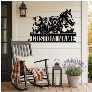 Puede incluir: Un letrero de pared de metal negro con un diseño recortado de oveja, pollo, conejo, perro, pato y caballo sobre una barra horizontal con el texto CUSTOM NAME. El letrero está montado en una pared de revestimiento blanco sobre una mecedora.