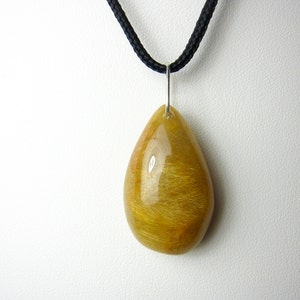 May include: A teardrop-shaped pendant made of golden rutilated quartz, with a silver bail and a black cord.