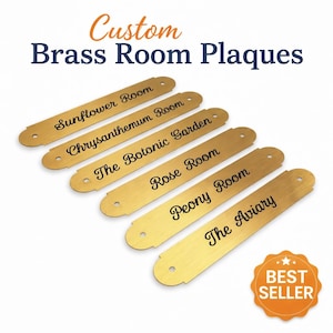 May include: Custom brass room plaques with engraved text. The gold-coloured plaques have rounded ends and pre-drilled holes. Text includes "Sunflower Room," "Chrysanthemum Room," and "The Aviary." A "Best Seller" badge is in the bottom right.