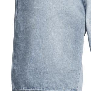May include: Close-up of light blue denim shorts. The shorts have a classic design with visible stitching and a textured fabric. The denim appears to be pre-washed, giving it a faded appearance. The image focuses on the fabric and construction details.