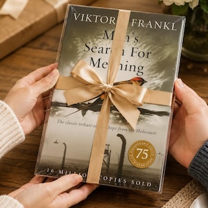 May include: A wrapped book titled "Man's Search for Meaning" by Viktor Frankl, with a gold ribbon and bow. The cover features a bird and the text "75th Anniversary Edition, 16 Million Copies Sold."