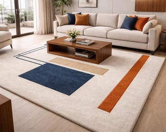 Puede incluir: Una alfombra rectangular grande con fondo crema y diseño geométrico. Presenta un rectángulo azul marino, un rectángulo beige y una franja naranja. La alfombra está en un salón con sofá y mesa de centro. Mide aproximadamente 300 cm x 200 cm.