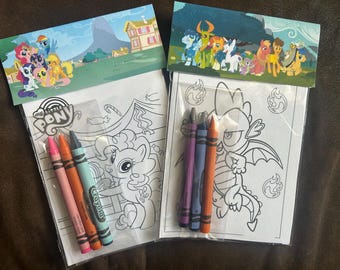 May include: Two My Little Pony coloring book sets with crayons. Each set includes a coloring book with line art and a header featuring colorful pony characters. One set has pink, orange, and blue crayons, the other has purple, blue, and orange crayons.