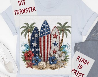 May include: DTF transfer design featuring three surfboards with an American flag theme, surrounded by palm trees, flowers, and seashells. The words "DTF TRANSFER" and "READY TO PRESS" are visible.