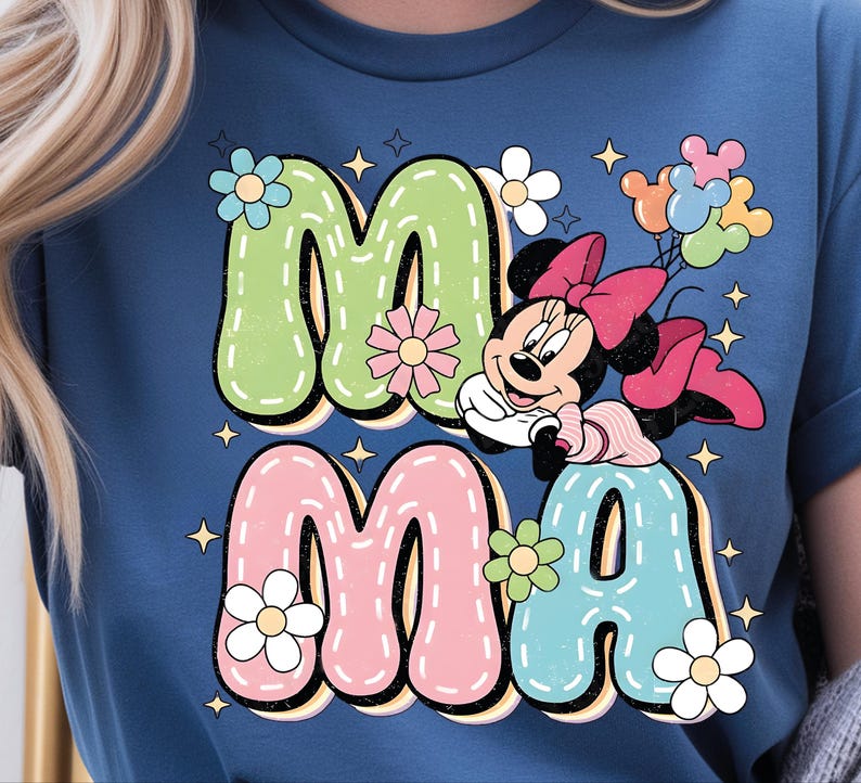Puede incluir: Camiseta azul con la palabra "MAMA" en letras grandes y coloridas y un gr&aacute;fico de Minnie Mouse. Las letras est&aacute;n delineadas en negro y decoradas con flores y estrellas. Minnie Mouse sostiene globos.