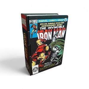 Peut inclure: Une boîte de rangement rectangulaire présentant la couverture de la bande dessinée The Invincible Iron Man numéro 150. L'illustration montre Iron Man et le Docteur Doom dans une scène de combat aux couleurs vives rouge, jaune et verte.