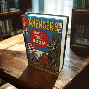 May include: A hardcover book with a comic book cover featuring "The Avengers" and "Enter... Dr. Doom." The cover art includes Captain America and Dr. Doom. The book is on a wooden surface, with a library in the background.