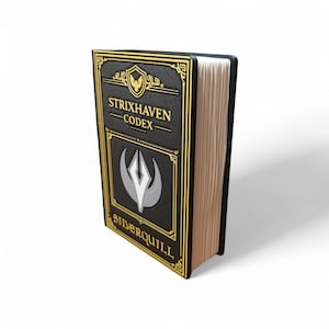May include: A black book with gold trim and the text "STRIXHAVEN CODEX SILVERQUILL". The book has a crest and a silver and white emblem on the cover. The pages are a light tan color.