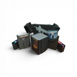 May include: Black card storage boxes with a silver character and gun graphic. The boxes are open, revealing stacks of cards and individual cards in protective sleeves. Designed for trading card games, the boxes are made of durable material.