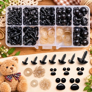May include: A clear plastic storage container filled with various sizes of black plastic safety eyes and translucent washers. Additional black safety eyes, paw-shaped plastic pieces, and washers are arranged on a cloth surface next to a teddy bear.
