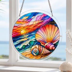 May include: A circular stained glass suncatcher featuring a vibrant sunset over the ocean with two seashells in the foreground. The design includes a yellow sun, blue waves, and a large fan-shaped shell alongside a spiral shell in warm tones.