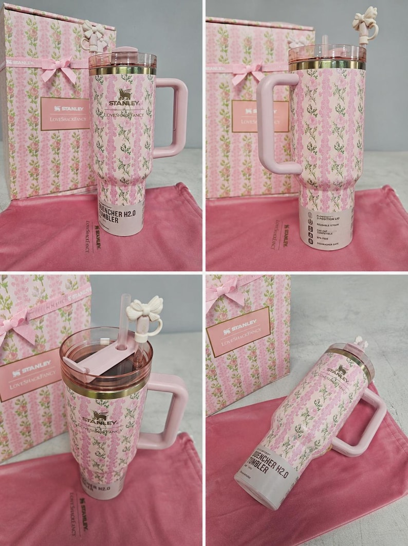 May include: A pink and white floral patterned Stanley Quencher H2.0 tumbler with a handle, straw, and lid. The tumbler is packaged with a matching gift box and a pink cloth. The tumbler has the Stanley logo and the words "Loves Fancy" printed on it.