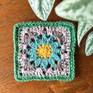 以下が含まれることがあります： 白いセラミックマグカップ、黒い持ち手、手書き風の「But First, Coffee」の文字。マグカップは白い面に置かれています。マグカップの高さは約10cmです。