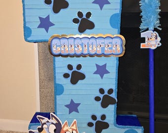 Bluey and Bingo piñata, measures 50 centimeters high by 35 centimeters wide, includes decorated stick.
