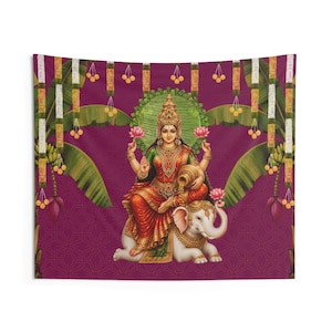 May include: A wall tapestry featuring a depiction of the Hindu goddess Lakshmi seated on a white elephant. She wears a red and gold sari, ornate jewelry, and holds lotus flowers. The background is deep purple with banana leaves and floral garlands.