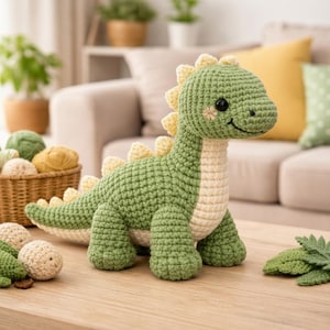 May include: A crocheted dinosaur toy in green and cream with yellow spines. The dinosaur has a smiling face and is on a wooden table. A basket of yarn and other crochet items are in the background.