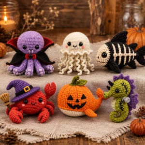 May include: Six crocheted Halloween-themed figures: a purple octopus vampire, a cream-colored jellyfish, a black and cream fish skeleton, a red crab wearing a purple witch hat with a broom, an orange pumpkin-shaped whale, and a green seahorse.