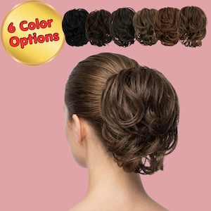 Op de afbeelding: Het haar van een vrouw gestyled in een knot, met zes kleuropties erboven weergegeven. De knot is donkerbruin met lichtere highlights. De tekst "6 Color Options" staat in een gouden cirkel.