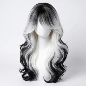 Op de afbeelding: Een lange, golvende pruik met een zwart-witte ombre-effect. De pruik heeft een gelaagde stijl met pony en volumineuze krullen. Het haar is gestyled op een witte mannequinhoofd.