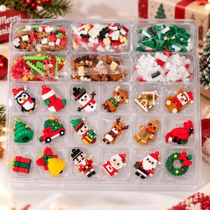 Könnte beinhalten: Ein durchsichtiges Kunststoff-Sortierfach mit verschiedenen kleinen Baustein-Sets und zwanzig fertigen Weihnachtsornamenten, darunter ein Pinguin, ein Schneemann, ein Rentier, ein Lebkuchenmann, der Weihnachtsmann und ein Kranz aus bunten Kunststoffsteinen.