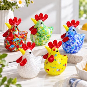 May include: Five small glass chicken figurines, each featuring a bright red comb and wattle, a yellow beak, and black eyes. The chickens are decorated with colorful speckled patterns in red, green, blue, white, and yellow, standing on a white surface.