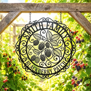 May include: A circular black metal sign featuring an intricate scrollwork border and a central design of blackberry clusters with leaves. The text SMITH FAMILY is arched at the top and BLACKBERRY PATCH is arched at the bottom in a serif font.