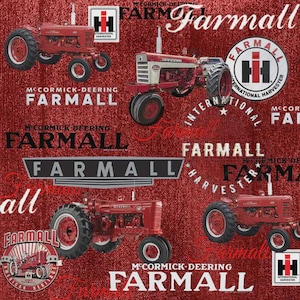 Op de afbeelding: Een rode stof met een herhaald patroon van vintage Farmall-tractoren en logo's. De tractoren zijn rood, met witte en zwarte letters met de tekst "Farmall" en "International Harvester". De achtergrond heeft een textuur.