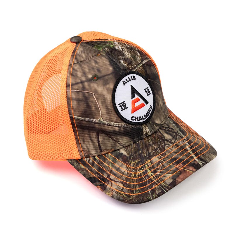 May include: A camouflage and orange trucker hat with a white circle patch that says "Allis Chalmers" with a red "A" inside the circle.