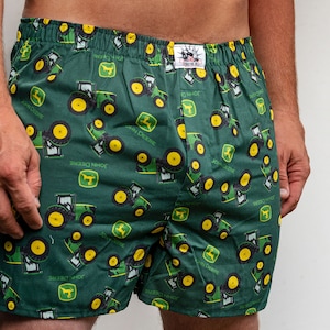 May include: Green boxer shorts with a repeating pattern of yellow and green tractors with the text "John Deere" on them.