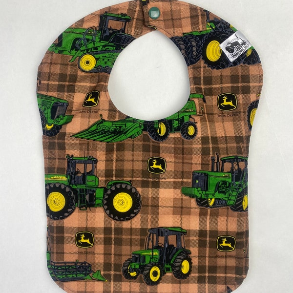 John Deere baby bib on brown plaid background