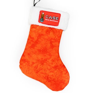 Puede incluir: Calcetín de Navidad naranja y blanco con un parche rojo con el logotipo de Case Farm Machinery. El logotipo incluye un águila y un globo terráqueo.